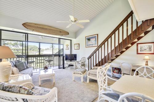 una sala de estar con muebles blancos y una escalera. en NorthShore Haven Condo, en Kahuku