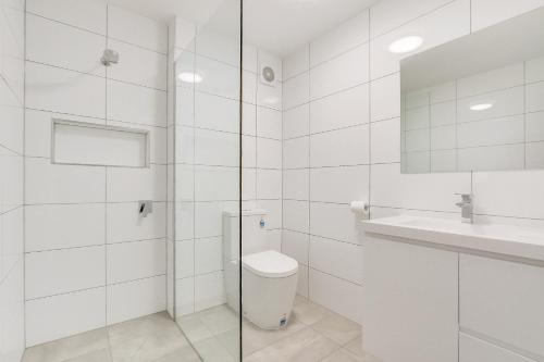 a white bathroom with a toilet and a sink at North Pier Hotel in Cowes