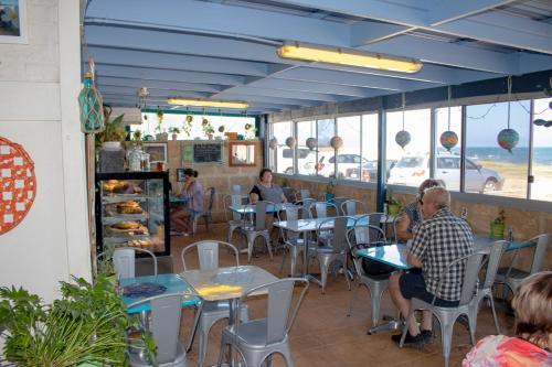 a group of people sitting at tables in a restaurant at Seaspray Beach Holiday Park in Dongara