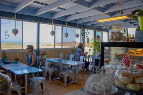two women sitting at tables in a restaurant at Seaspray Beach Holiday Park in Dongara