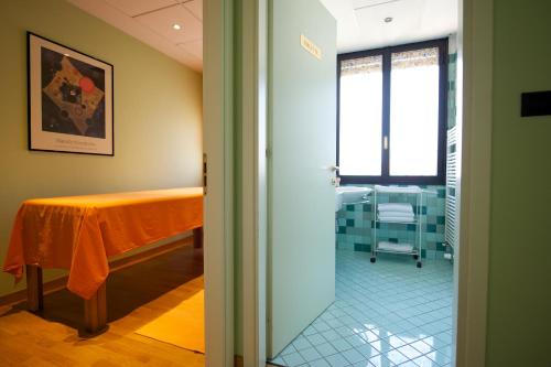 a hospital room with a table and a window at Mercure Reggio Emilia Centro Astoria in Reggio Emilia