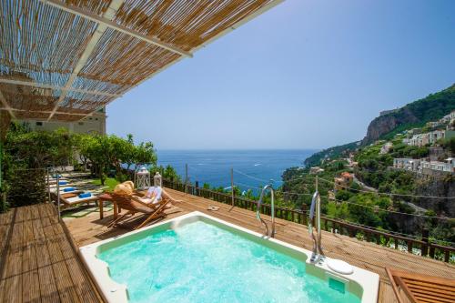 a person sitting in a chair next to a swimming pool at Villa Lauro Old Chapel in Amalfi