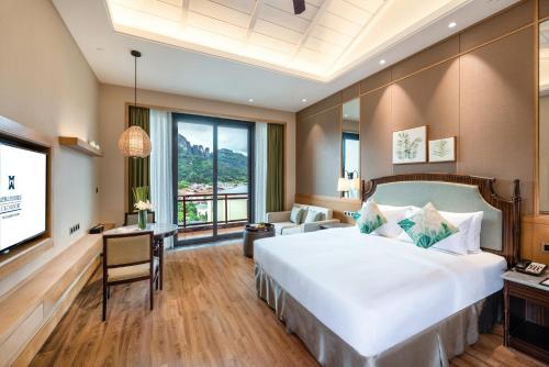 a hotel room with a large bed and a television at C&D Resort,Wuyi Mountain in Wuyishan