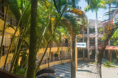a group of palm trees in front of a building at Flat com serviços na Riviera in Bertioga