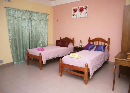 1 dormitorio con 2 camas, mesa y ventana en Lo de Margarita en San Salvador de Jujuy