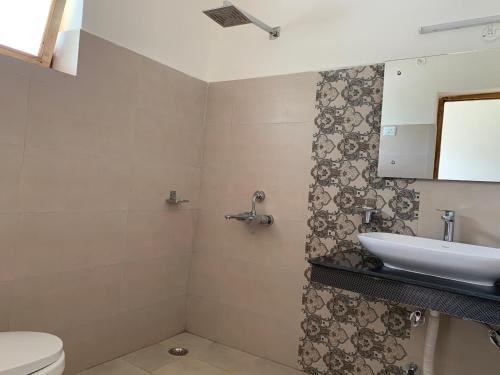a bathroom with a sink and a toilet at AMIGO LEH Guesthouse in Leh