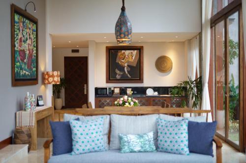 a living room with a couch with blue pillows at Tejaprana Bisma - CHSE Certified in Ubud