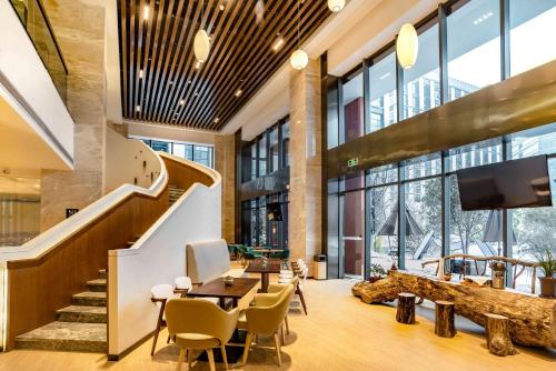hol ze schodami, stołem i krzesłami w obiekcie Atour S Hotel Hangzhou Future Tech City w mieście Hangzhou