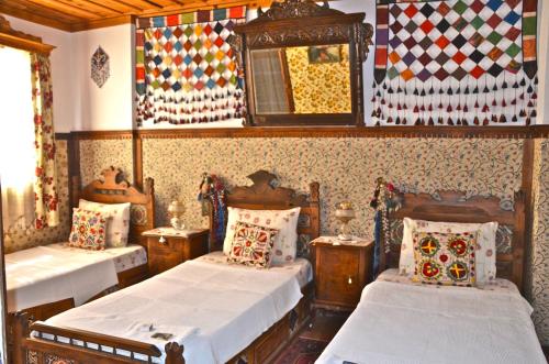 a bedroom with two beds and a mirror at Homeros Pension & Guesthouse in Selcuk