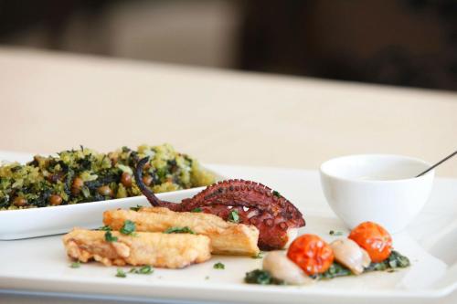 a plate of food with tomatoes and a bowl ofinoa at Parador Casa Da Insua in Penalva do Castelo