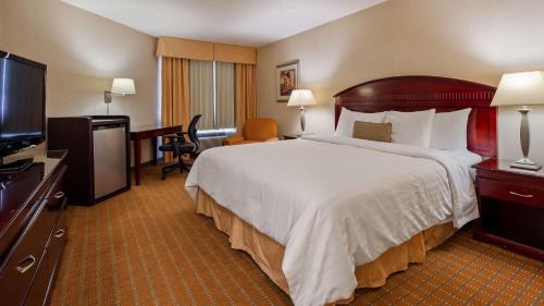 a hotel room with a large bed and a desk at Best Western Plus West Covina Inn in West Covina