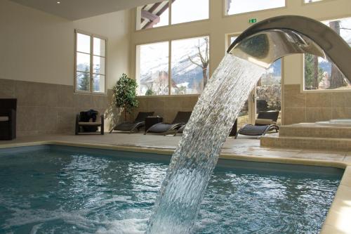 una fuente de agua en una piscina en Best Western Grand Hotel de Paris en Villard-de-Lans