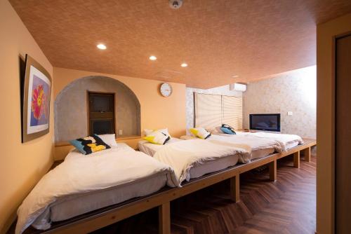 a row of beds in a room with at BEYOND HOTEL Takayama 2nd in Takayama