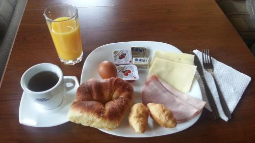 a plate of breakfast food with a cup of coffee and pastries at Guesthouse Trite Kambani in Banya