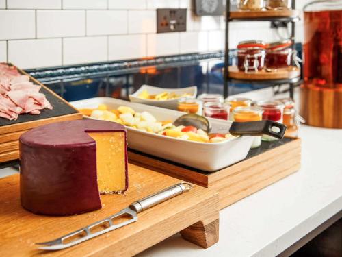 a cutting board with a cake and a plate of food at ibis Styles London Gloucester Road in London