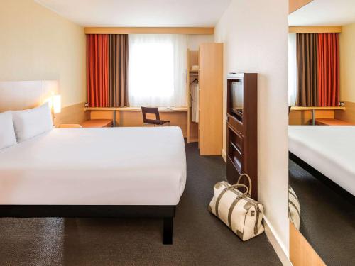 ein Hotelzimmer mit einem Bett und einem Schreibtisch in der Unterkunft Ibis Lugano Paradiso in Lugano