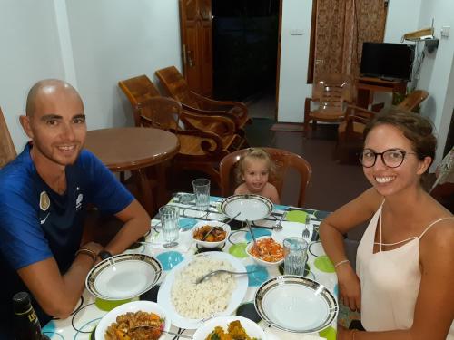 a man and a woman sitting at a table with food at Juda Holiday Villa in Batticaloa
