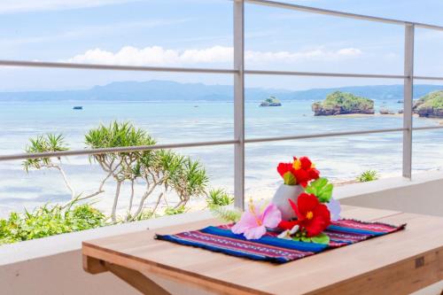 a room with a table with a view of the ocean at Suite villa Yagaji in Nago