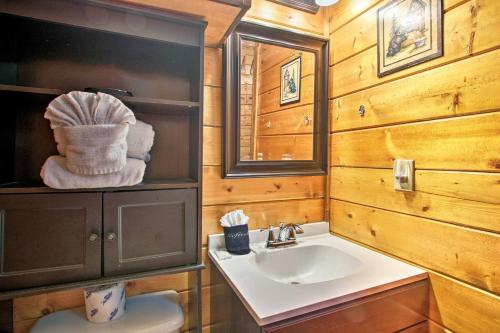 a bathroom with a sink and a toilet and a mirror at River Rush- Cozy Riverfront Cabin 5 Mi to Pigeon Forge in Sevierville