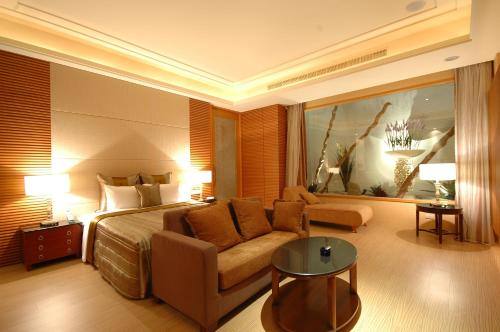 a hotel room with a bed and a couch at MUDU BREEZE MOTEL in Shulin