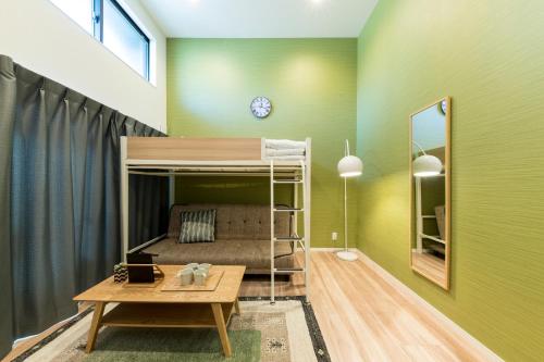a bedroom with a bunk bed in a green wall at TRIP POD MINOSHIMA A in Fukuoka