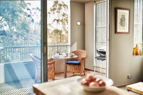 a room with a balcony with a table and chairs at Riversdale Retreat in Chewton