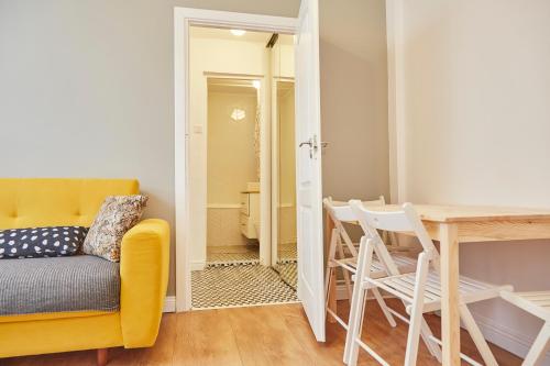 ブカレストにあるLola’s apartament close to city centerの黄色いソファとテーブルのあるリビングルーム