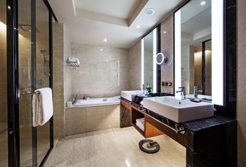 uma casa de banho com um lavatório e uma banheira em Swiss Grand Nanchang em Nanchang