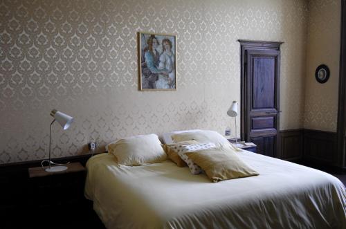 a bedroom with a large bed with white sheets at Château de Villemorien in Villemorien