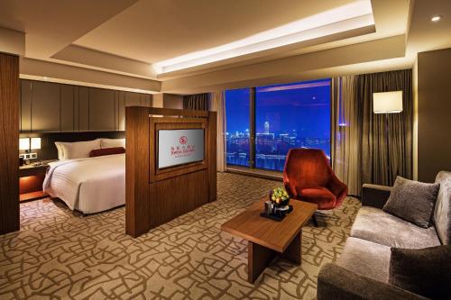 a hotel room with a bed and a couch at Swiss Grand Nanchang in Nanchang