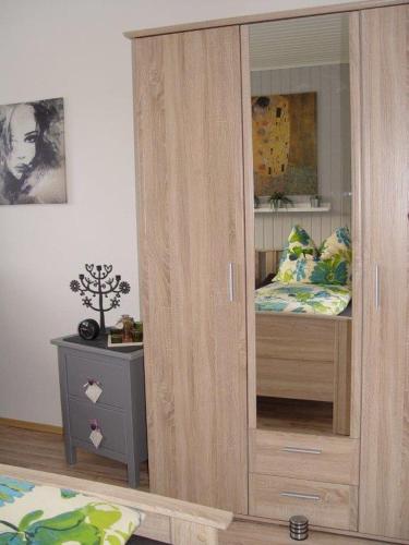 a large wooden cabinet in a room with a bed at Ferienwohnung am Blauen See in Dorsten in Dorsten