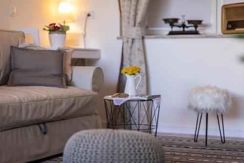 a living room with a couch and a table with a chair at Relax Village Home Mare in Krk