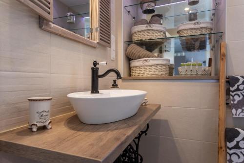 een badkamer met een wastafel en een plank met manden bij Relax Village Home Mare in Krk