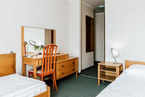 a bedroom with a desk and a chair and a mirror at Hotel Gromada Łomża in Łomża