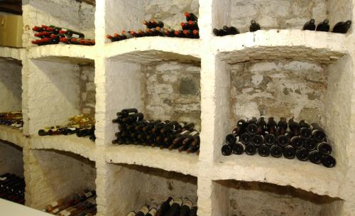 a wall filled with bottles of wine on shelves at L'Étape Fagnarde - Bed, Breakfast & Sauna in Spa