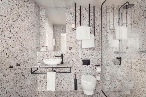 a bathroom with a toilet and a sink and a shower at Blique by Nobis, Stockholm, a Member of Design Hotels™ in Stockholm