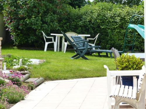 a group of chairs and a table in a yard at LE RUBAN BLEU FACE A LA MER in Arromanches-les-Bains