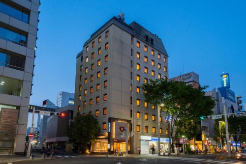 a tall building on a city street at night at Hotel S-plus Nagoya Sakae in Nagoya