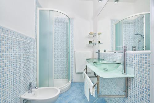 a white bathroom with a sink and a toilet at Hotel Antares in Capoliveri