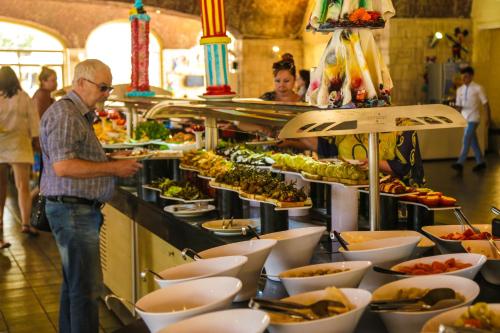 un uomo in piedi davanti a un buffet di cibo di Fortezza Beach Resort a Hisarönü