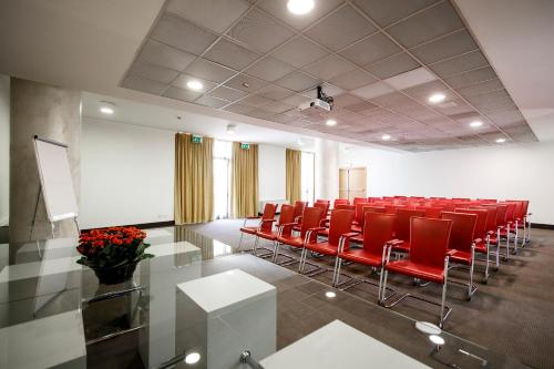 a conference room with red chairs and a table at Airporthotel Verona Congress & Relax in Dossobuono