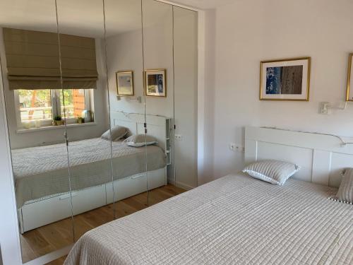 a bedroom with two beds and a mirror at apartament Wakacje w Rowach in Rowy