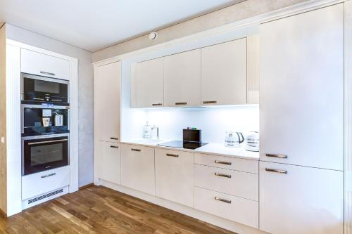 a white kitchen with white cabinets and appliances at Pallasti Luxury Apartment in Tallinn