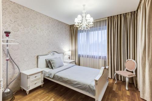 a bedroom with a white bed and a chandelier at Pallasti Luxury Apartment in Tallinn