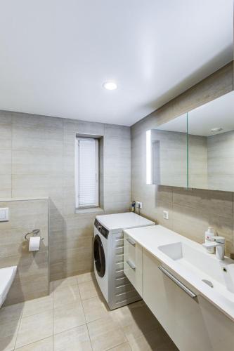 a bathroom with a washing machine and a sink at Pallasti Luxury Apartment in Tallinn