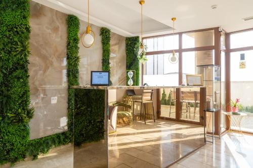a lobby with a green wall with a table and chairs at Hotel Manor in Mamaia Nord