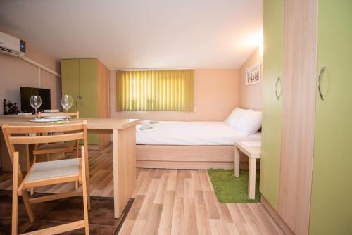 Kleines Zimmer mit einem Bett, einem Schreibtisch und einem Tisch in der Unterkunft Central Rooftop Studio TK31 in Burgas City