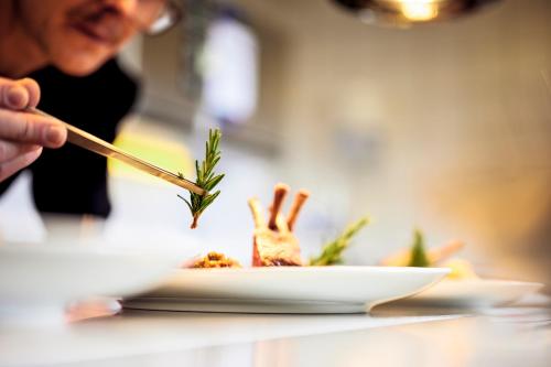 a person eating food on a plate on a table at Pension Alpenfluh in Lech am Arlberg
