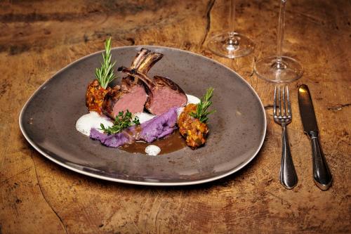 a plate of food with meat and vegetables on a table at Pension Alpenfluh in Lech am Arlberg