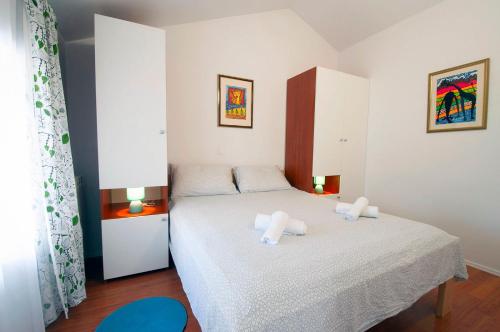 a bedroom with a bed with two pillows on it at Apartment Dva Oriha in Funtana